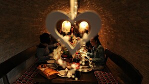 A group of people dining in a brick-walled room with a heart-shaped decoration in the center. - Mikin dol Baranja Country House (Draz)