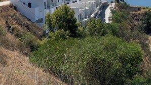 A modern white building with multiple balconies, situated on a hillside with a view of the sea. - Casa Grace (Nerja)