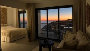 A hotel room with a large window, a bed, a sofa, and a small table. - Casa Grace (Nerja)