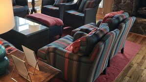A cozy living room with striped sofas, a coffee table, and a fireplace. - Brigantine Cottage - Experience both an Ocean AND Bay Family Vacation  this year (Brigantine)