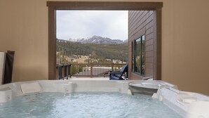 A hot tub with a mountain view, a deck, and a chair. - Beaverhead Village Haven | Hot Tub • Walk to Big Sky (Big Sky)