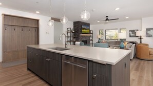 A modern kitchen with a large island, built-in appliances, and pendant lighting. - Beaverhead Village Haven | Hot Tub • Walk to Big Sky (Big Sky)