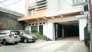A building with a modern design, featuring a garage entrance and a staircase leading to the upper floor. - Cozy Residence Cipedes Bandung (Bandung)