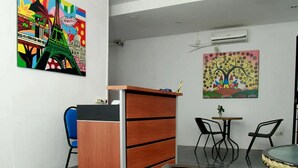 A room with a wooden desk, two chairs, a small table, and two wall-mounted air conditioners. - Cozy Residence Cipedes Bandung (Bandung)