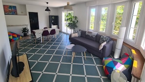 A spacious living area with a sofa, dining table, and colorful cushions. - Town house on the banks of the vienne (Châtellerault)