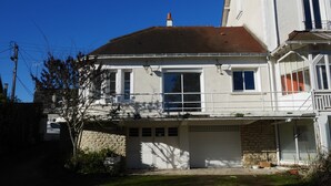 A two-story house with a garage, a stone foundation, and a red-tiled roof. - Town house on the banks of the vienne (Châtellerault)