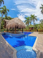 Una piscina al aire libre, sillones reclinables de piscina