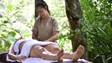 Guests can enjoy a rejuvenating massage under the shade of a tree in a serene natural setting.