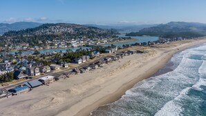 Vista aérea de un pueblo costero con playa, casas y un lago.