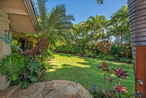 Un jardin bien entretenu, avec un chemin de pierres menant à une maison.