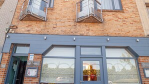 A hotel with a brick facade, large windows, and a blue entrance. - Hotel Monaco Zeebrugge Beach (Bruges)