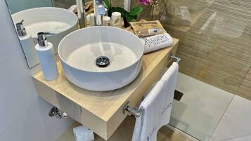 A modern bathroom with two large sinks, a mirror, and a towel rack.