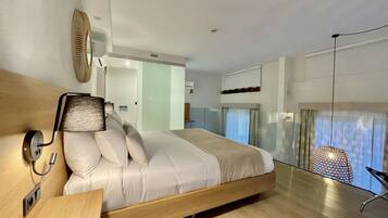 A modern bedroom with a wooden bed, a bedside table, a wall-mounted lamp, and a large window with a view.