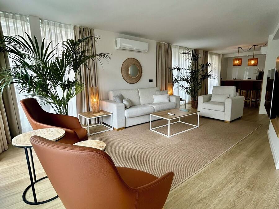 A modern living room with a sofa, armchairs, and a coffee table.