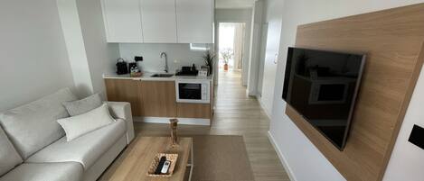 A modern living room with a sofa, coffee table, and a TV mounted on the wall.