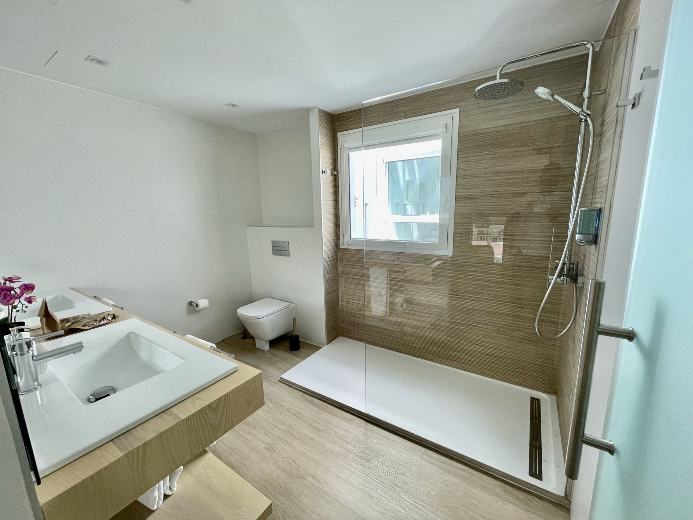 Un baño moderno con bañera, ducha, inodoro y lavamanos.