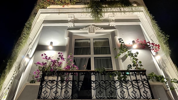 Entrada de un hotel con un cartel que dice 'HOTEL HI SUITES'.