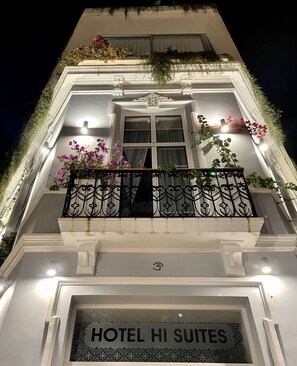 Entrada de un hotel con un cartel que dice 'HOTEL HI SUITES'.