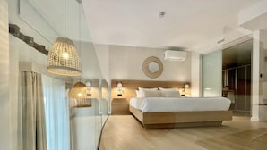 Un dormitorio moderno con una cama grande, lámparas de noche, aire acondicionado instalado en la pared y un separador de vidrio.