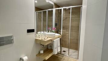 Un baño moderno con inodoro, lavamanos y zona de ducha.