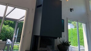 A modern kitchen with a built-in oven, large windows, and hanging pendant lights. - Architect's villa Lyon Collonges au mont d'or: Swimming pool, Nature, Bocuse, (Collonges-au-Mont-d'Or)