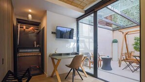 A modern room with a large sliding glass door leading to an outdoor area, a flat-screen TV mounted on the wall, and a dining table with chairs. - Diagonal Amazing 3BD with private garden (Barcelona)