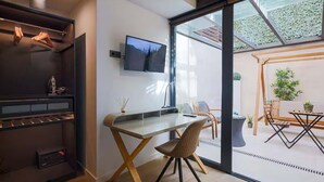A modern room with a desk, chair, and a TV mounted on the wall. - Diagonal Amazing 3BD with private garden (Barcelona)