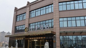 A hotel with a modern facade, large windows, and a prominent entrance. - Ji Hotel (Shanghai)