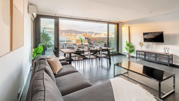 A modern living room with a sofa, dining table, and TV.