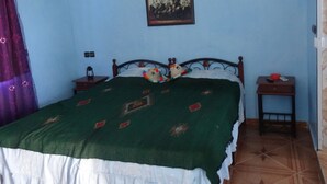 A bedroom with a bed, a nightstand, a lamp, and a framed picture on the wall. - Come all, for an exceptional stay. (Tahla)