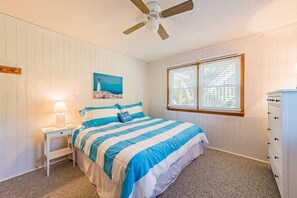 A bedroom with a bed, a nightstand, a lamp, a ceiling fan, a window, and a dresser. - Coker Cabana - Duck, Carolina Dunes, Oceanside, 400 Yds to Beach, Sound Access, Flex Stays (Duck)
