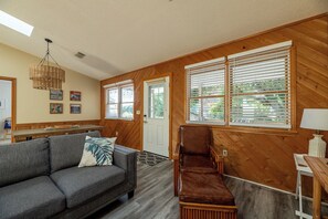 A cozy living room with a sofa, a chair, and a dining table. - Coker Cabana - Duck, Carolina Dunes, Oceanside, 400 Yds to Beach, Sound Access, Flex Stays (Duck)
