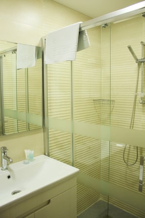 Suíte estúdio superluxo | Banheiro | Chuveiro, produtos de toalete grátis, secador de cabelo, chinelos