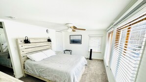 A bedroom with a bed, a ceiling fan, a window with blinds, and a door. - Spacious 4-BR, 2.5 Bath vacation home: Foosball, 65" TV, Golf, 4 Season Room (Sioux Falls)