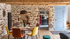 Comedor de paredes de piedra con techo de madera, chimenea de piedra y un letrero que dice "SEPTUNE".