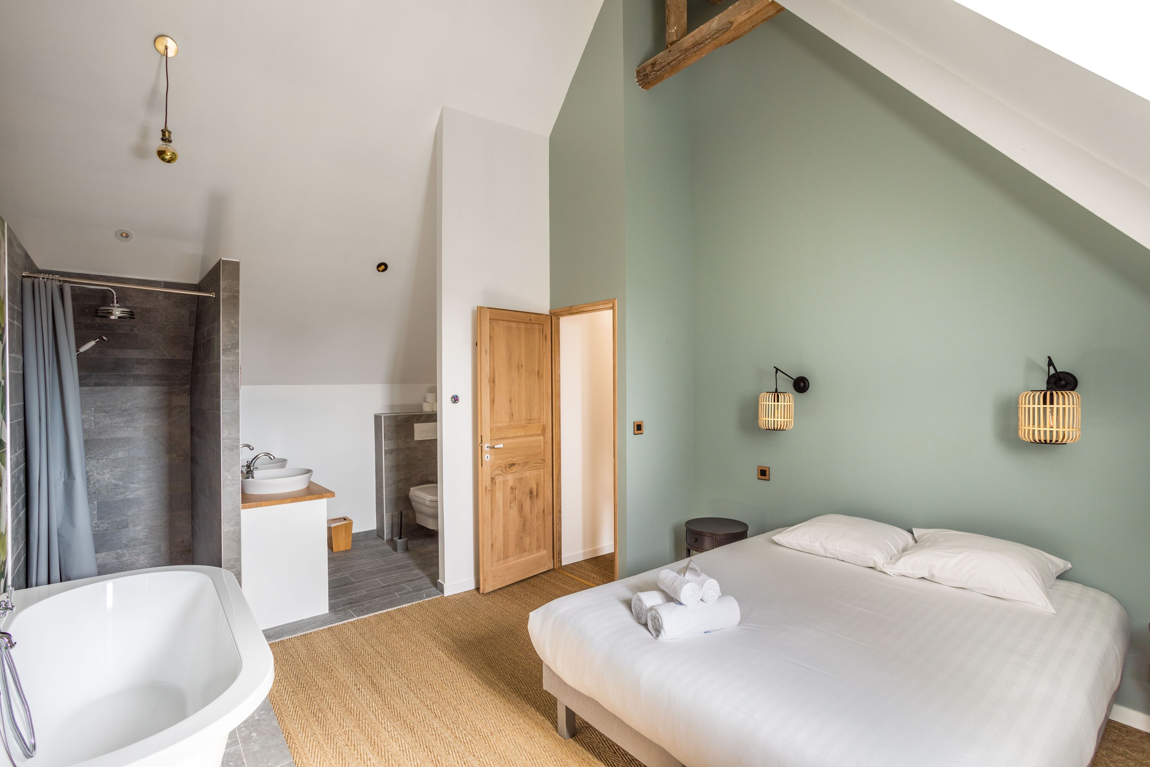 Un dormitorio con una cama grande, un baño con bañera y ducha.