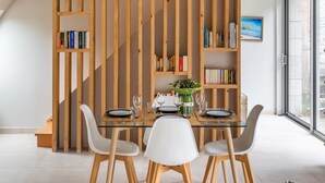A dining area with a high wooden ceiling, a staircase, and bookshelves. - Ar Chadenn - Maison d'architecte (Saint-Cast-le-Guildo)
