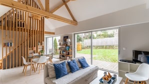 A modern living room with a sofa, coffee table, and bookshelves. - Ar Chadenn - Maison d'architecte (Saint-Cast-le-Guildo)