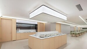 A modern kitchen with a central island, wooden cabinets, and a large window. - JI Hotel (Yuncheng Yanhu Tiaoshan Street) (Yuncheng)