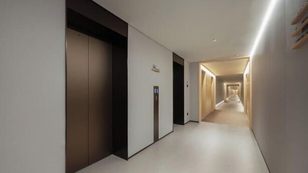 A modern hotel corridor with a straight path leading to an elevator and a staircase. - JI Hotel (Yuncheng Yanhu Tiaoshan Street) (Yuncheng)