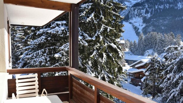 A balcony with a wooden railing overlooking a snowy mountain landscape with cabins. - 3rd floor, balcony, tv, 64m², Pralognan-la-Vanoise (Pralognan-la-Vanoise)