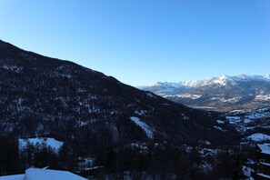 A mountainous landscape with snow-covered peaks and a clear sky.