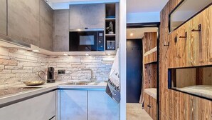 Una cocina moderna con salpicadero de piedra, un microondas integrado y armarios de madera.