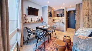 Una habitación de hotel moderna con comedor, kitchenette y una zona de estar acogedora.