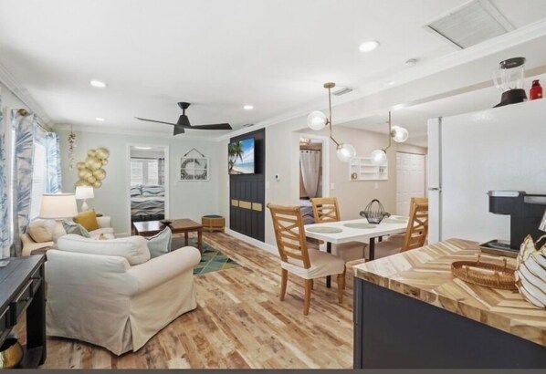 A modern living room with a sofa, dining table, and chairs.
