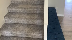 Eine Treppe mit Teppichstufen, die zu einer Zwischenebene führt.