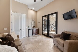Relax in this open-plan living space featuring a kitchen, comfortable seating area, and sliding glass door to an outdoor area.