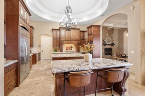 Enjoy cooking in this well-equipped kitchen with a central island, stainless steel appliances, and wooden cabinetry.