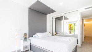 A modern bedroom with a bed, bedside tables, a mirror, and a view of the outdoors. - Seimar 1-8 Apartment Levante Beach (Benidorm)