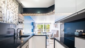 A modern kitchen with a black countertop, white cabinets, and a view of the outdoors. - Seimar 1-8 Apartment Levante Beach (Benidorm)